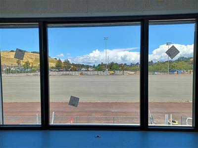 Through the window is the stadium field with the softball field beyond